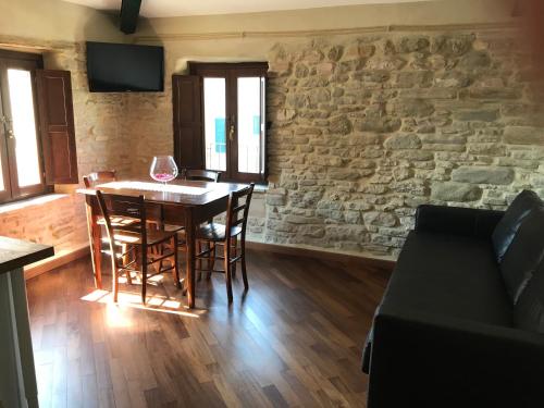 a dining room with a table and a stone wall at il sogno di Tino in Cabernardi