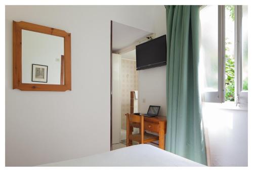 リョレート・デ・マルにあるホテル ニネイスのベッドルーム1室(ベッド1台、鏡、デスク付)