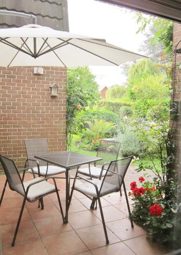 a table and chairs with an umbrella on a patio at Les Chambourlettes in Mons