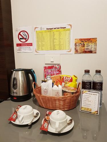 a counter top with a basket of food and a tea kettle at Siam Oriental Hotel in Hat Yai