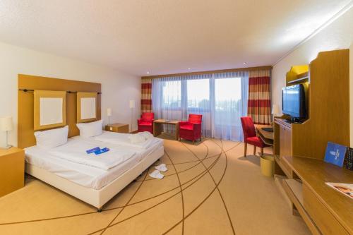a hotel room with a bed and a television at Hotel Schönbuch in Pliezhausen