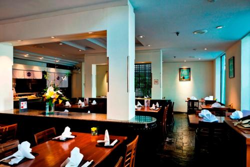 a restaurant with tables and chairs and a bar at Royal Princess Larn Luang - SHA Extra Plus in Bangkok