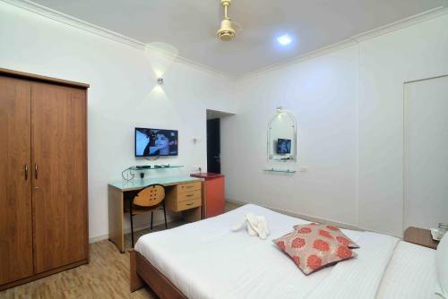 a bedroom with a bed and a desk in it at ShreeVilla Corporate Guest House in Nashik