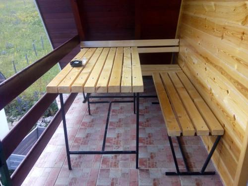a wooden bench sitting on top of a balcony at Rooms Apartment Durmitor in Žabljak