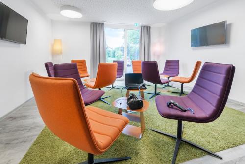 una sala de espera con sillas y una alfombra verde en Hotel Schönbuch, en Pliezhausen