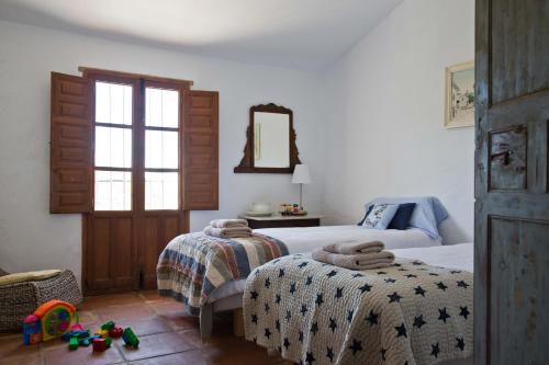 a bedroom with two beds and a mirror at Cortijo Juan Salvador in Olías