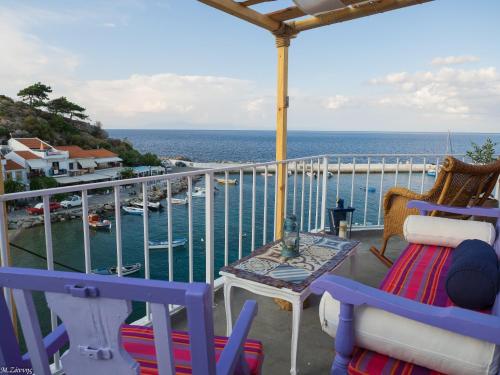 a balcony with chairs and a table and the ocean at Kokkari Traditional House in Kokkari