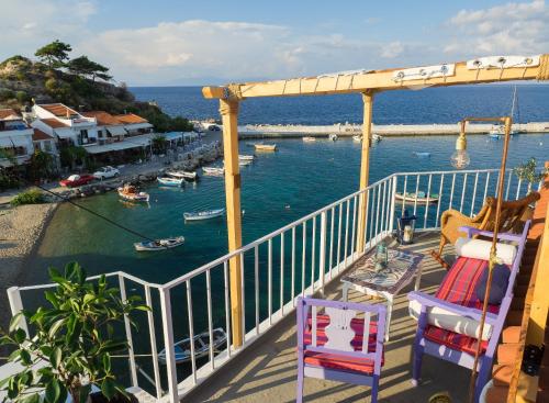 a balcony with two chairs and a view of a harbor at Kokkari Traditional House in Kokkari