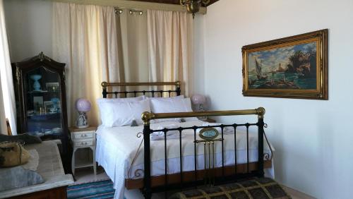 sypialnia z łóżkiem i obrazem na ścianie w obiekcie Kokkari Traditional House w mieście Kokkari
