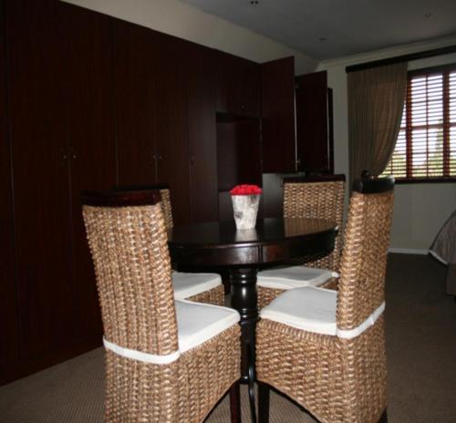 a dining room with a table and wicker chairs at Panorama Self Catering 2 in Panorama