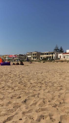 a sandy beach with buildings in the background at Matteo's home in Donnalucata
