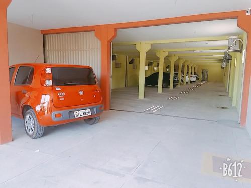 una furgoneta naranja estacionada dentro de un garaje en Pousada Tianguá, en Luís Correia