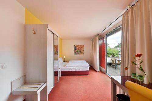 ein Hotelzimmer mit einem Bett und einem Balkon in der Unterkunft Hotel Neutor Express in Salzburg