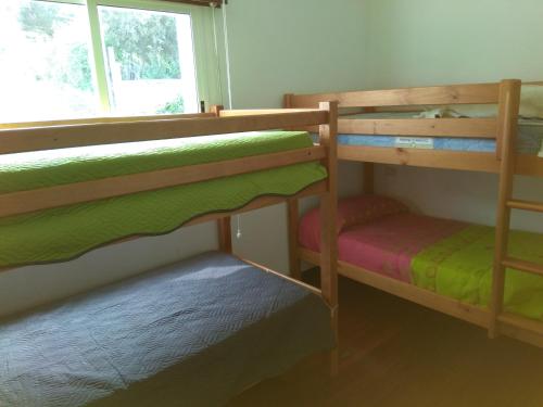 two bunk beds in a room with a window at Secondary home in Lobios