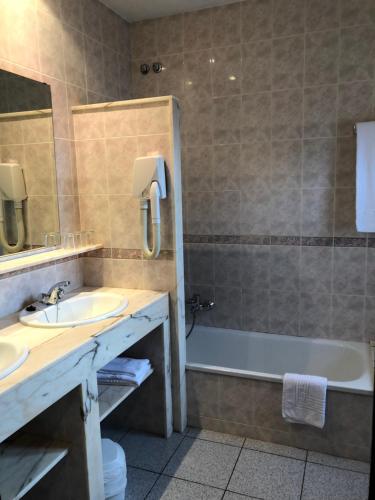 ein Badezimmer mit einem Waschbecken, einer Badewanne und einem WC in der Unterkunft Hostal de la Gloria in Viladrau
