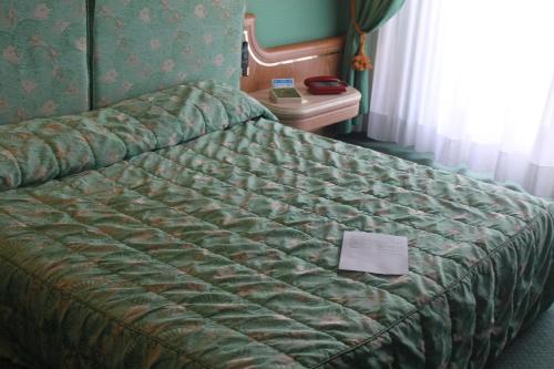 a bed in a hotel room with a paper on it at 501 Hotel in Vibo Valentia
