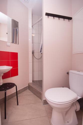 a bathroom with a toilet and a sink and a shower at La Guitarra Hostel Gdańsk in Gdańsk
