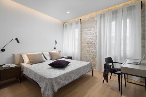 a bedroom with a large bed and a desk and a desk at Apartment Fianona - Rovinj city center in Rovinj