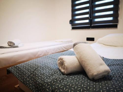 a bedroom with two beds and a towel on the bed at Holiday home Green coast in Bosanska Krupa