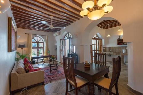 a dining room and living room with a table and chairs at The Seyyida Hotel and Spa in Zanzibar City