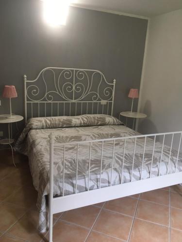 a bed in a room with two tables at Villaggio Fiorito Casale in Pignone
