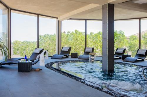 a pool in the middle of a building with chairs and tables at Casa Font i Roig in Maria de la Salut