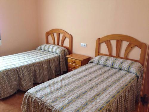a hotel room with two beds and a night stand at Chalet en el Monte con Piscina in Sagunto