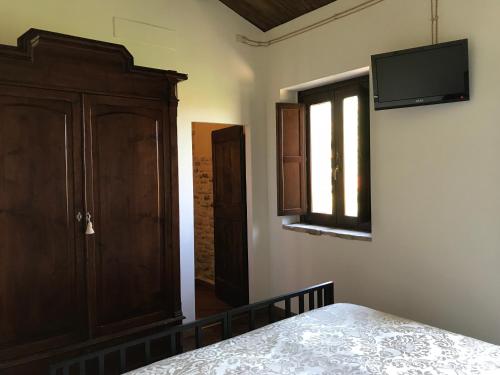 a bedroom with a bed and a tv on the wall at il sogno di Tino in Cabernardi