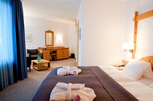 a hotel room with two towels on a bed at Hotel Rosatsch in Pontresina