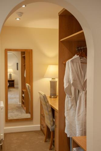 a room with a desk and a mirror at The H Boutique Hotel in Bakewell