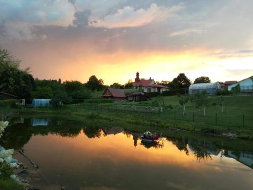 a sunset over a river with a boat in it at Griežto 5 in Zarasai