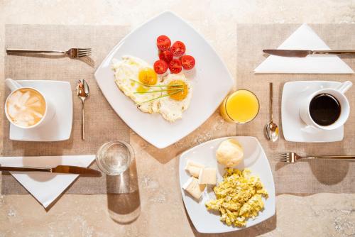 a table with plates of breakfast food and coffee at Relais dei Molini - Villa dei Molini in Castagneto Carducci