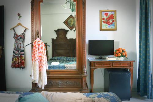 a bedroom with a mirror and a bed and a television at Hotel La Riva in Giardini Naxos
