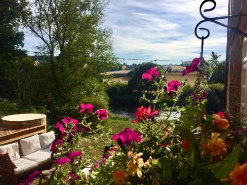 a garden with pink flowers and a couch at Worralls Grove Guest Farm House in Bewdley