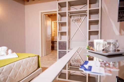 a room with a closet with a bed and a table at Relais dei Molini - Villa dei Molini in Castagneto Carducci