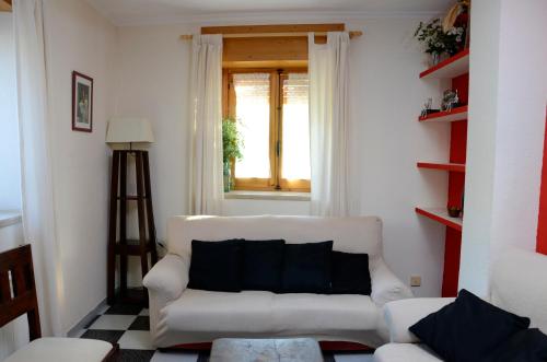 sala de estar con sofá blanco y ventana en Casa Rural ALCARREÑA, en Sigüenza