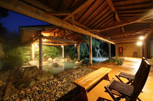 a patio with a pool and a table and chairs at Tenjukunomori Keigetsu in Mine