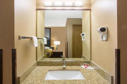 a bathroom with a sink and a large mirror at Super 8 by Wyndham Baker City in Baker City