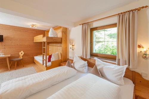 a hotel room with two beds and a window at Naturhotel BERGhof in Pfunds