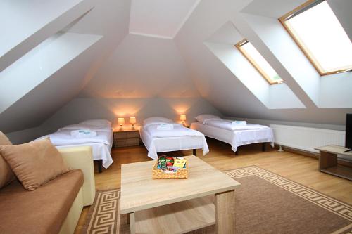 a attic room with two beds and a couch at Apartamenty Olsztyn in Olsztyn