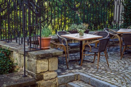 a patio with tables and chairs and a fence at Hotel Fortna in Chrudim
