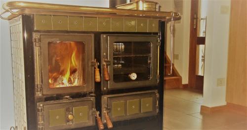 a wood stove with a fire inside of it at Il Casotto in Telve