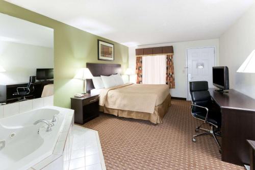 a hotel room with a bed and a bath tub at Super 8 by Wyndham Decatur/Dntn/Atlanta Area in Decatur