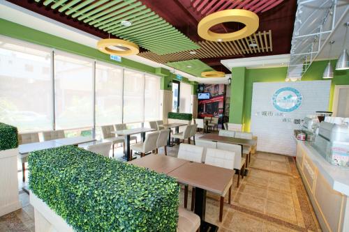 a dining room with tables and chairs and windows at Taitung Venice B&B in Taitung City