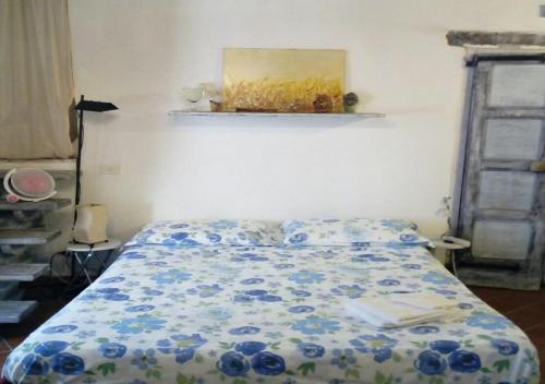 una camera da letto con un letto con fiori blu sopra di Tufoletto a Pitigliano