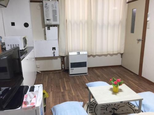 a living room with a tv and a table at Happy Apartment in Sapporo
