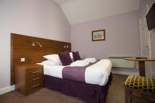 a hotel room with a large bed and a table at Georgian House & Mews in York