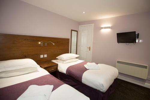 um quarto de hotel com duas camas e uma televisão de ecrã plano em Georgian House & Mews em York
