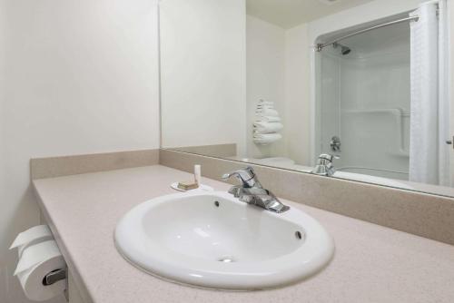 a white bathroom with a sink and a mirror at Super 8 by Wyndham Mississauga in Mississauga