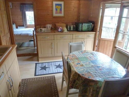 a kitchen with a table and a room with a bed at Hillside Self Catering in Salisbury